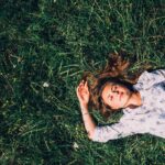 woman lying on grass during daytime